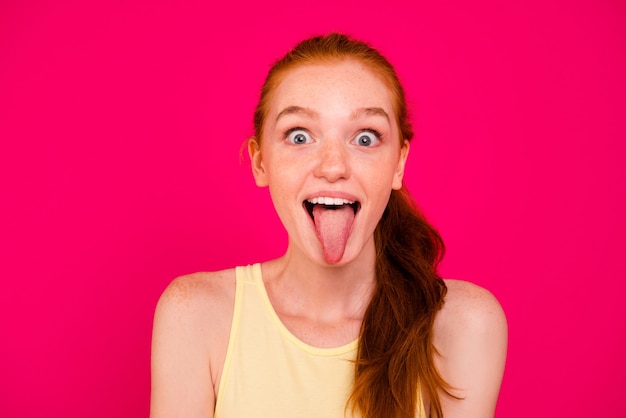 Photo portrait beautiful redhead girl isolated over pink wall