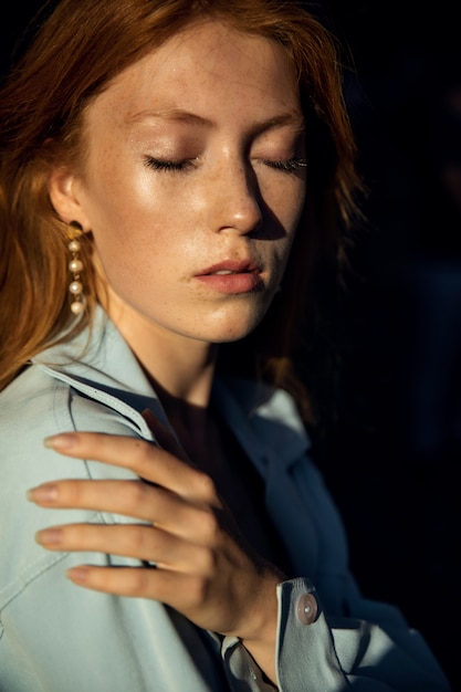 Foto ritratto di una donna bella rossa in una camicia blu