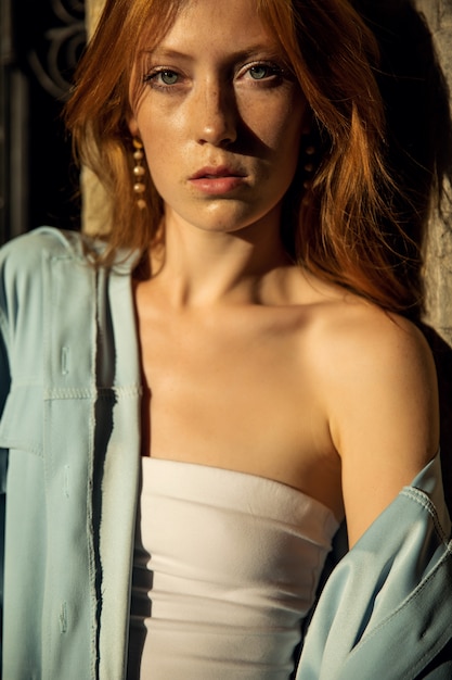 Portrait of a beautiful redhead woman in a blue shirt