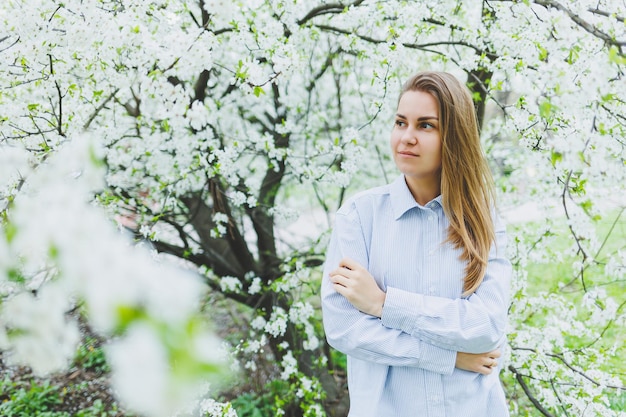 Portrait of beautiful romantic lady in apple trees blossoms