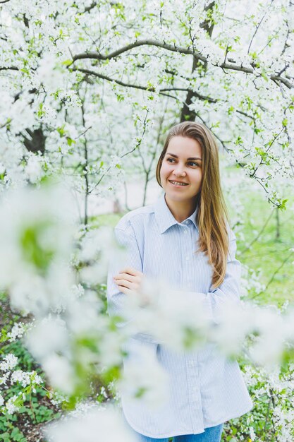 Portrait of beautiful romantic lady in apple trees blossoms