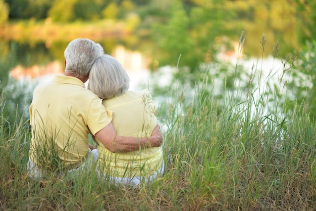 Portrait of beautiful senior couple hugging in the park back view