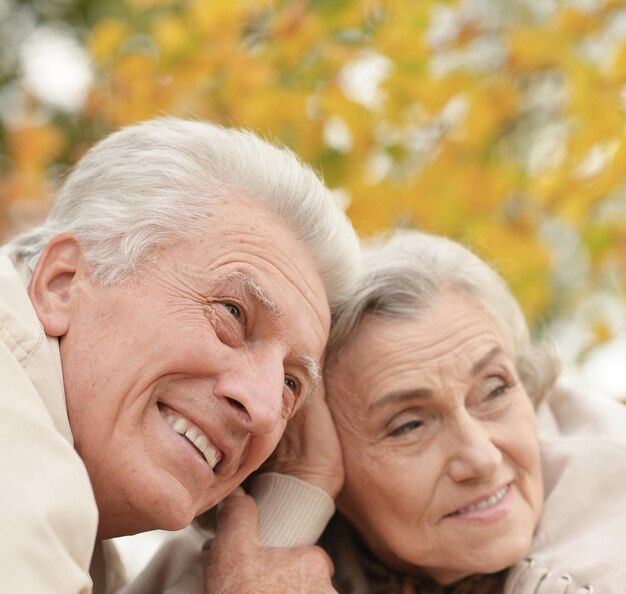 Portrait of beautiful senior couple lying in park