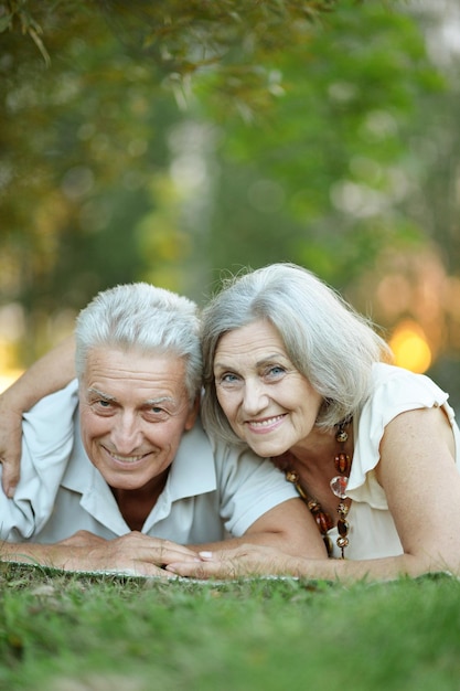 Portrait of beautiful senior couple lying in park