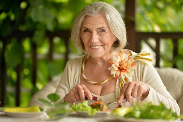 食べる美しい年配の女性の肖像画