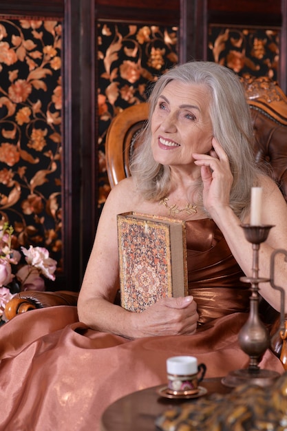 Portrait of a beautiful senior woman in golden dress