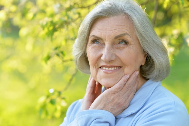 Portrait of a beautiful senior woman in green park