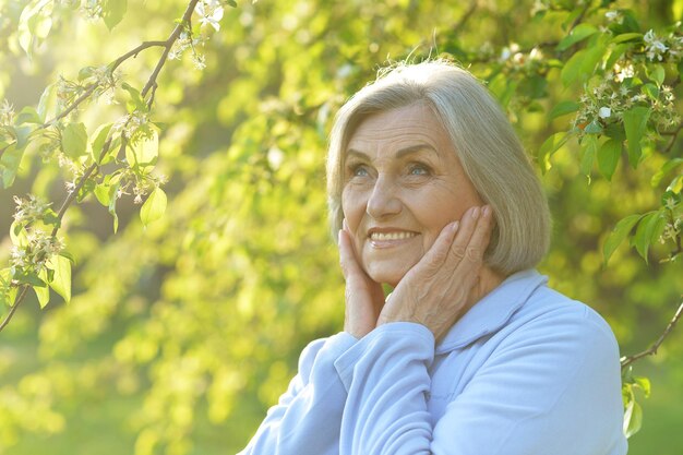 Portrait of a beautiful senior woman in green park