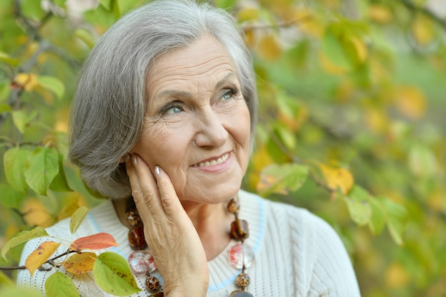 Portrait of a beautiful senior woman in green park