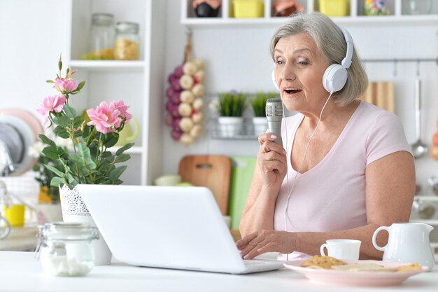 Portrait of beautiful senior woman singing with microphone