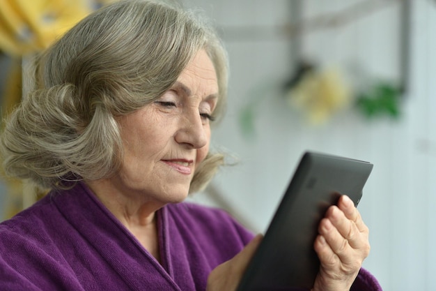 Portrait of a beautiful senior woman using modern tablet