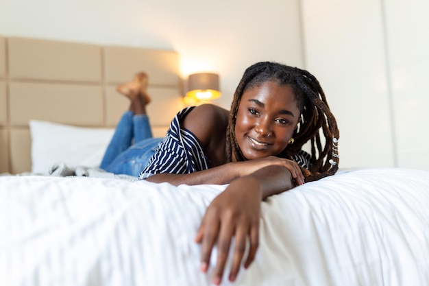 Portrait of beautiful and sensual african young woman lying on\
bed beautiful woman lying in bed