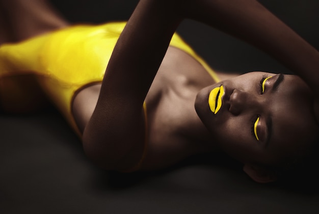 Ritratto di bella donna di colore sensuale nel corpo giallo
