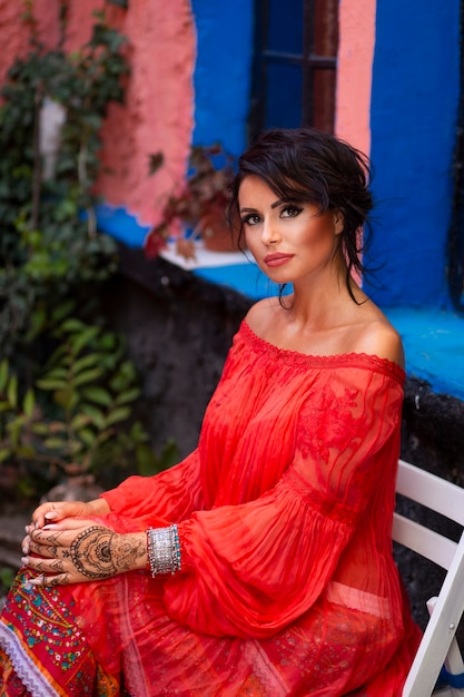 Portrait of a beautiful sensual elegant brunette girl, with make-up and fashion red outfit. Gipsy style.