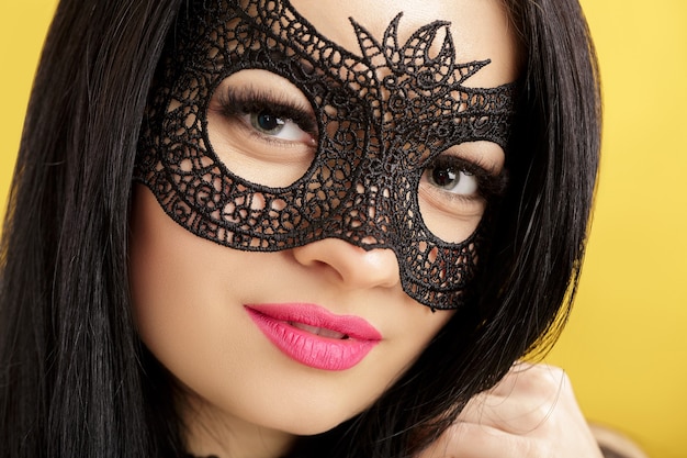 Portrait of beautiful sensual woman in black lace mask. sexy woman in venetian mask