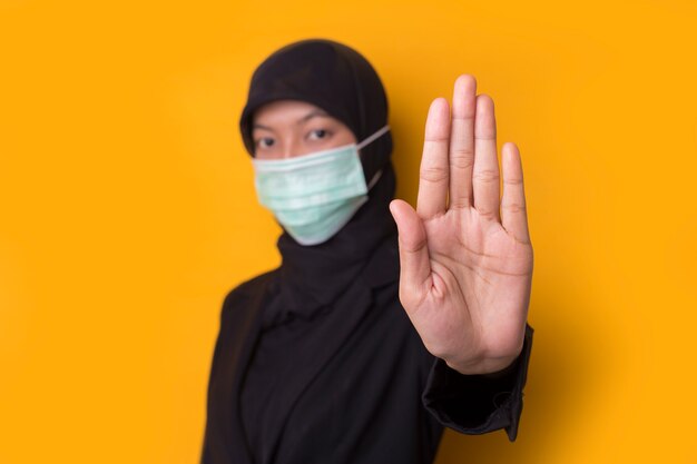 Portrait of a beautiful serious young Muslim woman wearing a face mask