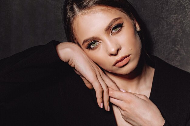 Portrait of a beautiful sexy girl with expensive and high-quality makeup on a dark background. Creative makeup theme. Portrait on the background of cosmic spots of light.