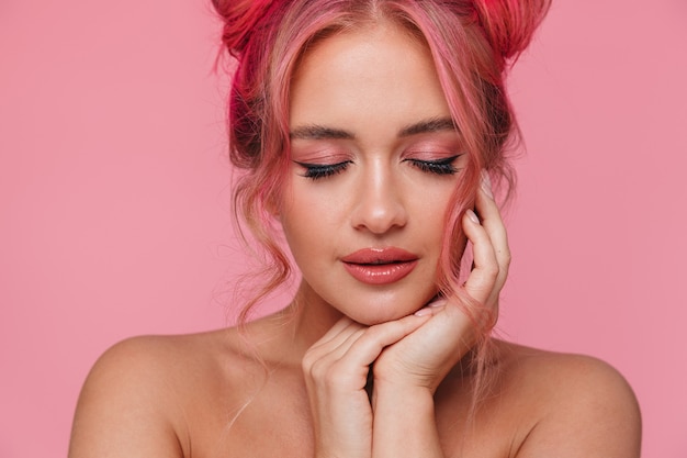 Portrait of beautiful shirtless young woman with colorful hairstyle and makeup standing with eyes closed