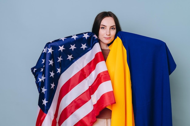 Portrait of a beautiful and smart girl with American and Ukrainian flags covered on both sides