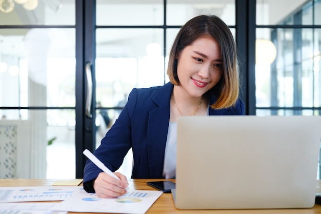 Portrait of beautiful and smart young entrepreneur businesswoman working in modern work station.