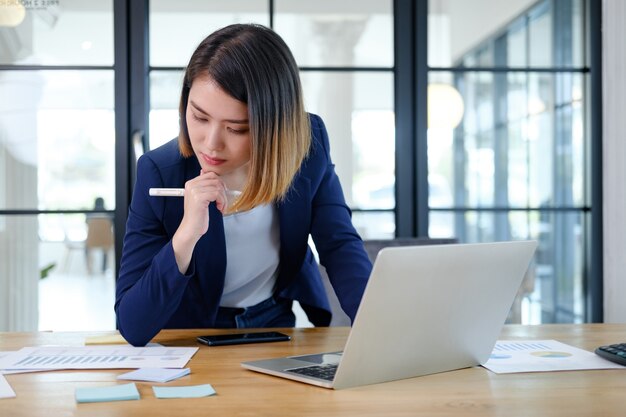 現代のワークステーションで働く美しくて賢い若い起業家の実業家の肖像画。