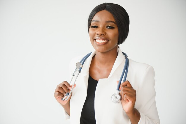 Ritratto di bello medico afroamericano femminile sorridente che sta nell'ufficio medico. concetto di assistenza sanitaria, assicurazione medica, copia dello spazio.