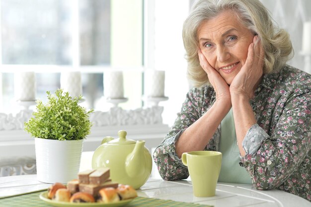 Portrait of beautiful smiling senior woman drinking tea