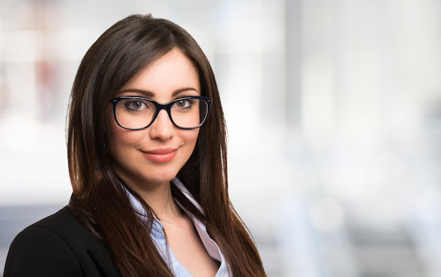 Portrait of a beautiful smiling swoman holding her eyeglasses