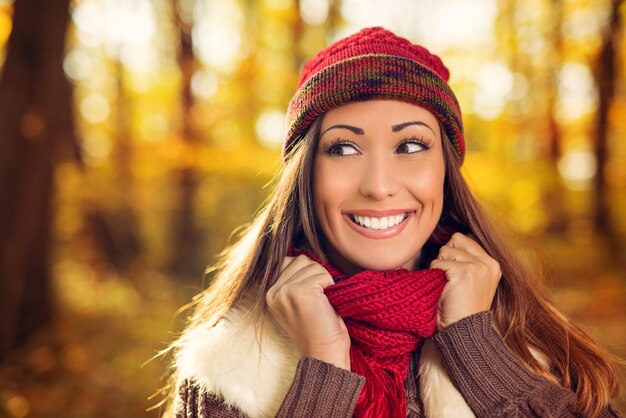 Portrait of a beautiful smiling woman in forest in autumn.