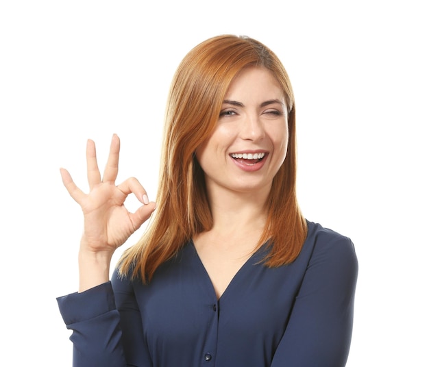白い背景に OK のジェスチャーを示す美しい笑顔の女性の肖像画