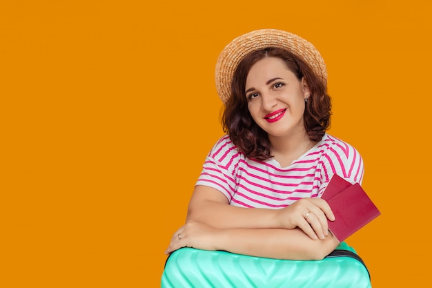 Portrait of a beautiful smiling woman with dark curly hair in a boater hat .