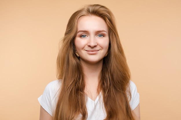 Ritratto di bella giovane posa dai capelli rossi sorridente della donna