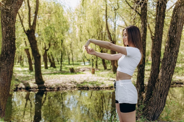 Portrait of a beautiful sports woman stretching legs outdoors