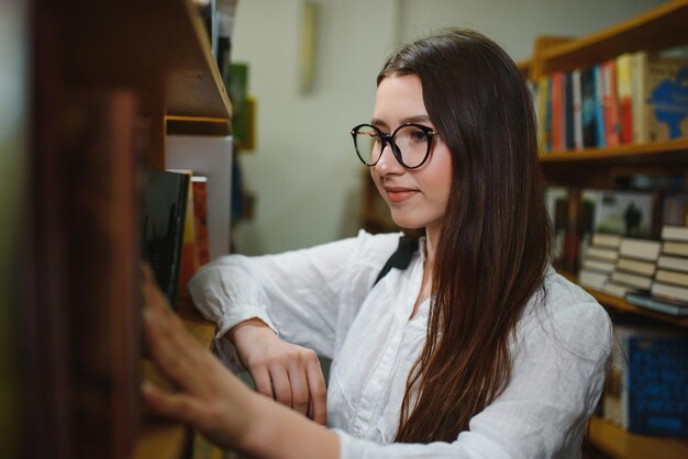 美しい学生の図書館での肖像