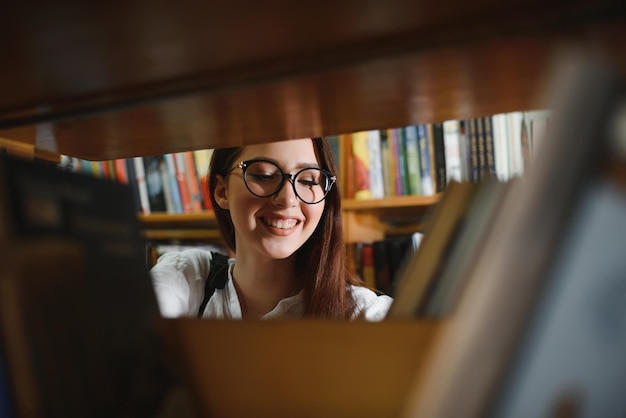 美しい学生の図書館での肖像