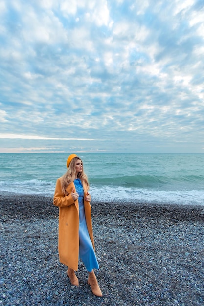 寒い季節の海岸で暖かい服を着た美しいスタイリッシュな女性の肖像画