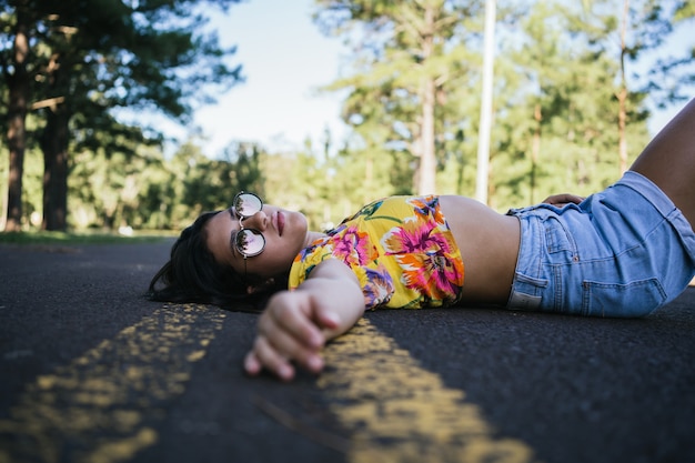 Portrait of a beautiful teenage girl lying on the pavement.