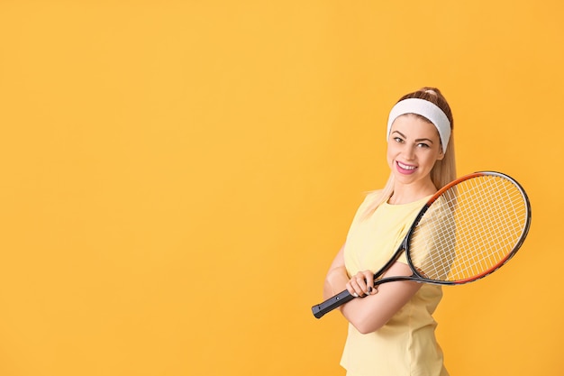 Portrait of beautiful tennis player on orange