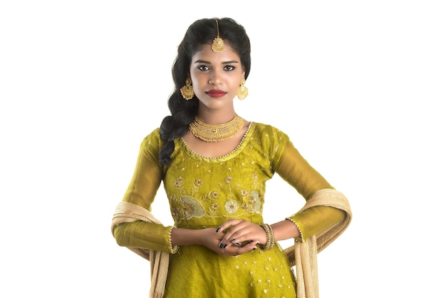 Portrait of beautiful traditional indian girl posing on white wall.