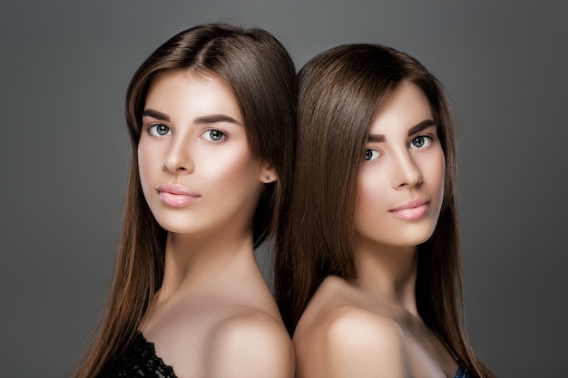 완벽한 피부와 자연스러운 화장, 긴 머리를 가진 아름다운 쌍둥이 여성의 초상화. 패션