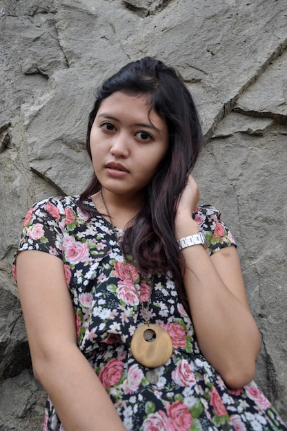 Portrait of beautiful woman against rock