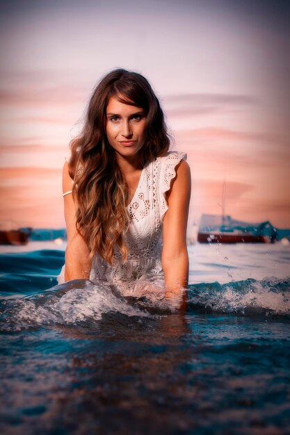 Foto ritratto di una bella donna contro il mare durante il tramonto