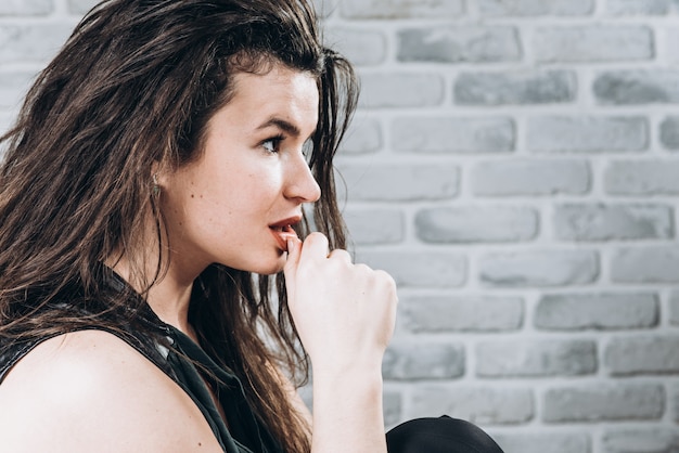 Portrait of a beautiful woman on the background of a light brick wall