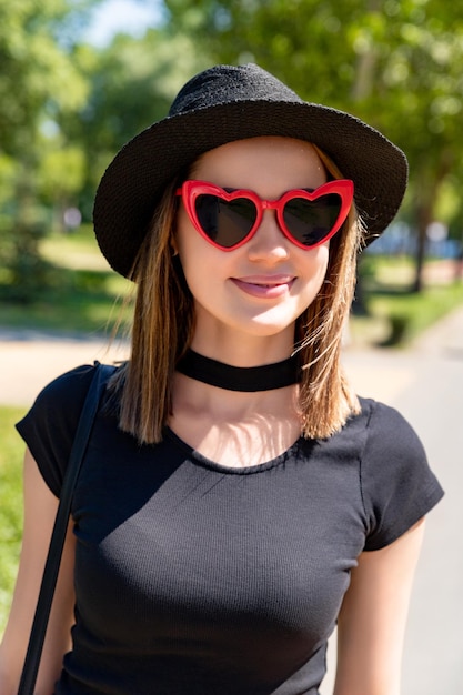 Portrait of beautiful woman in black tshirt and red skirt walking in the park