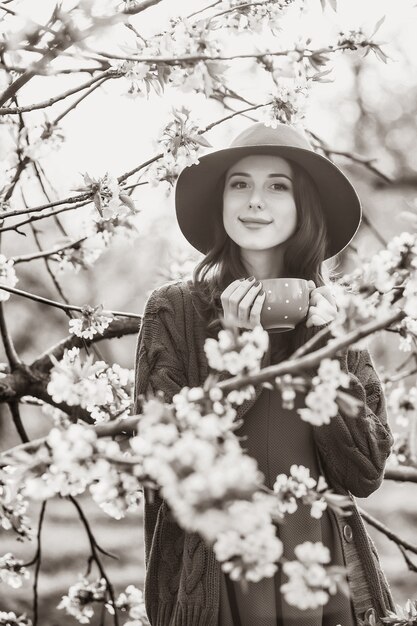 Portrait of a beautiful woman in blossom apple tree garden in spring time on sunset. Image in black and white color style