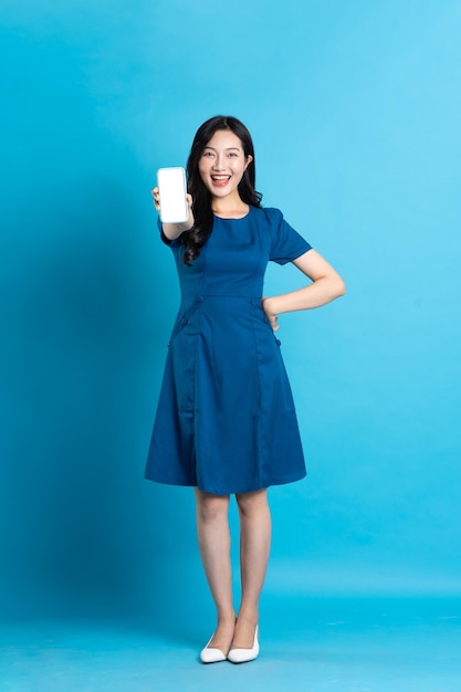 Portrait of beautiful woman in blue dress isolated on blue background