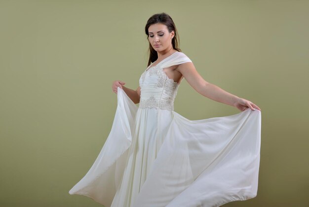 Portrait of a beautiful woman dressed as a bride isolated on white background in studio