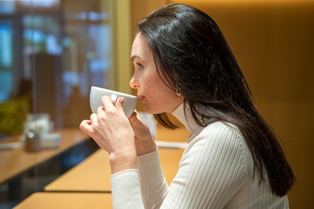 portrait of beautiful woman drinking coffee at a bar in a cafe