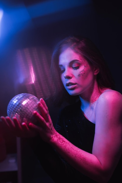 Photo portrait of a beautiful woman from the 8039s dancing in a dark room at a party with a disco ball