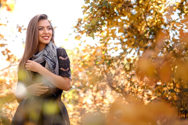 Portrait of beautiful woman in gray scarf in autumn